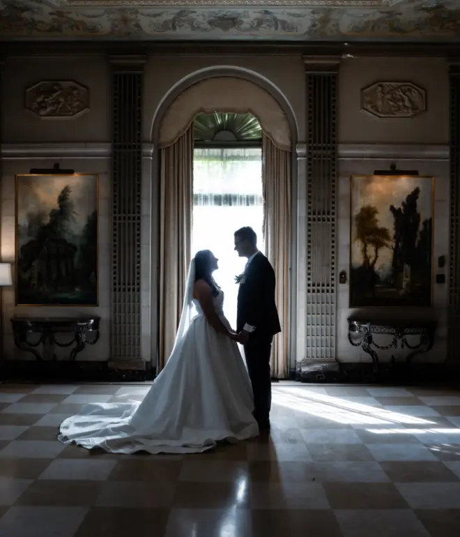 Bride and Groom standing in front of a window